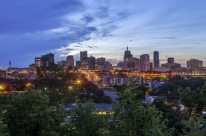 The St. Cloud skyline from across the water at dusk as the lights come on, posing the question, Are you lookin for a bankruptcy lawyer near Me in St. Cloud, MN