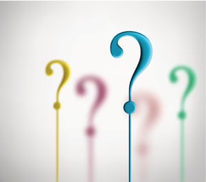 Photo of five plastic question marks on thin post much like drink stirrers; the yellow, magenta, orange and green question marks are blurred against a white background, with a turquoise question mark in focus in the foreground. The question marks represent the question of, What bankruptcy should I file?