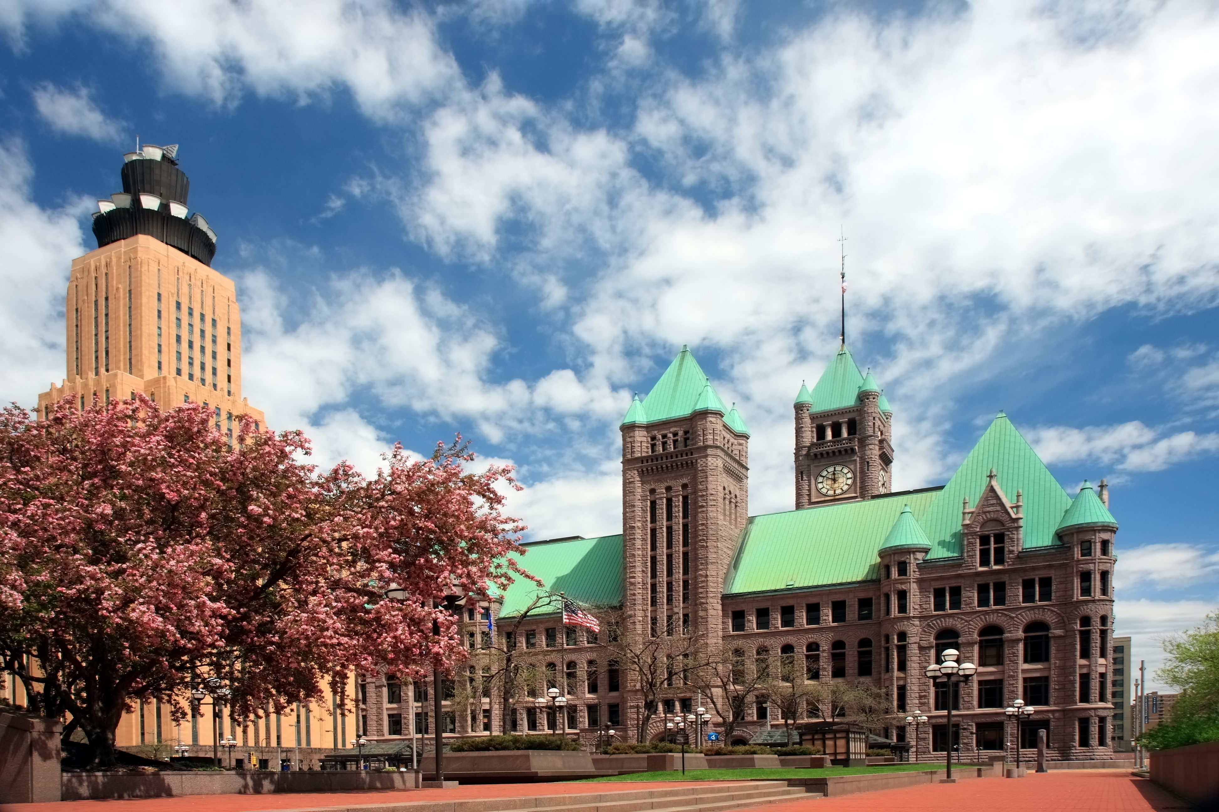 Minneapolis City Hall is a large Richardsonian Romanesque architecture brownish building with a light seafoam green roof, and where 341 Meetings for filing bankruptcy are held.