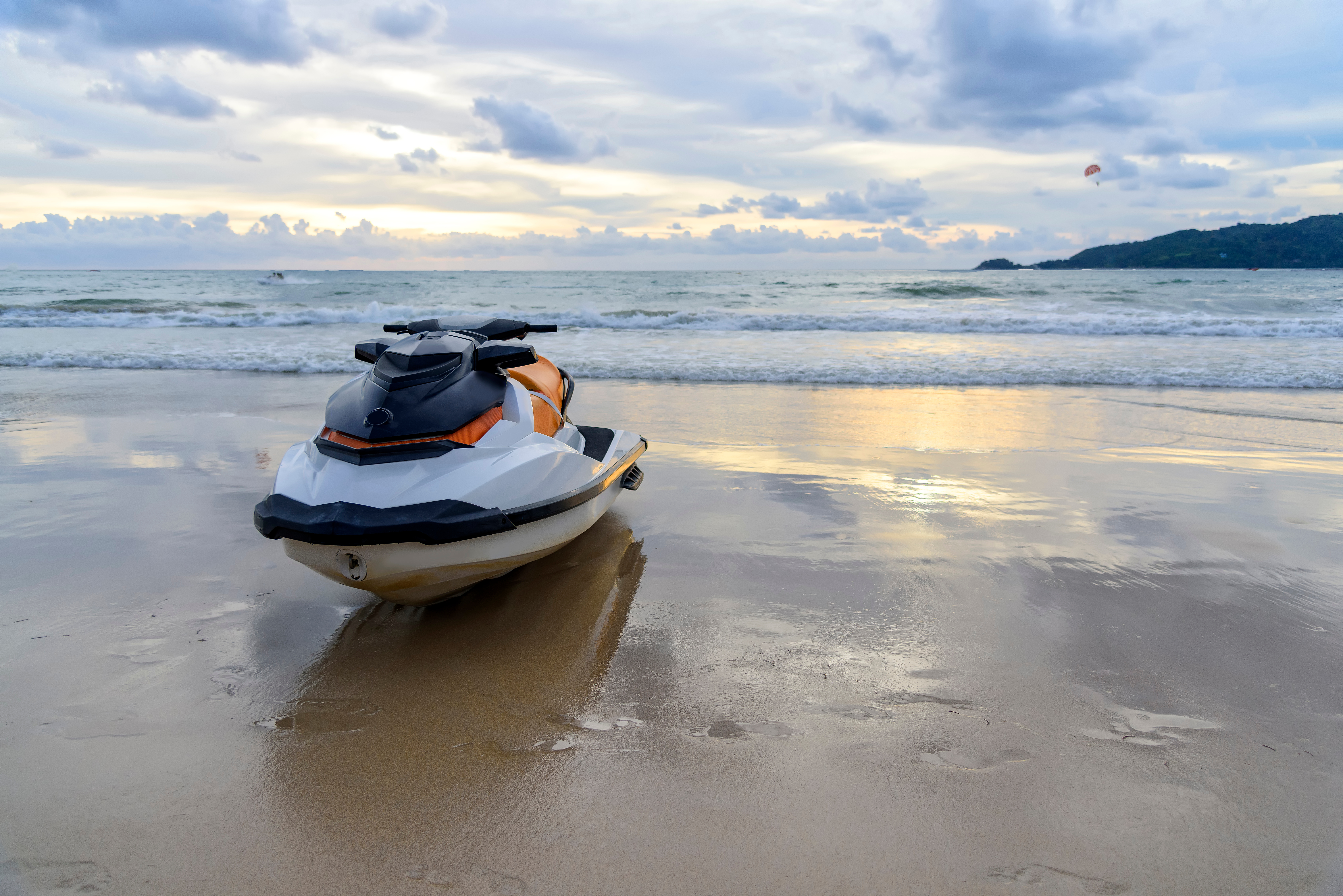 A white and yellow jet-ski on the shore's wet sand, with the ocean and a small bit of land in the background, posing the question, What is the process for handling unprotected property in a chapter 7 bankruptcy in Minnesota?