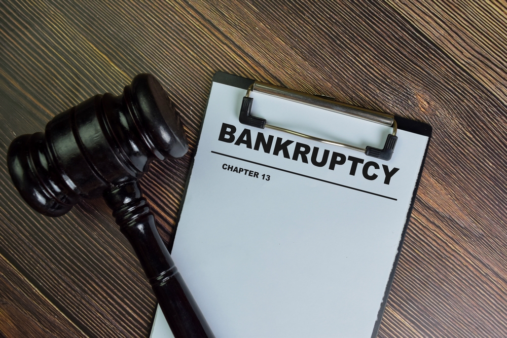 Bankruptcy - Chapter 13 write on a paperwork isolated on Wooden Table.